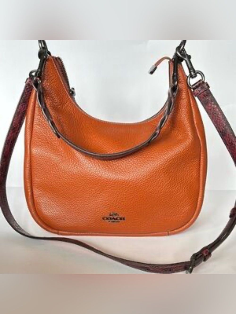 Coach Jules Hobo bag in Sunset pebble leather, featuring snake-embossed straps
